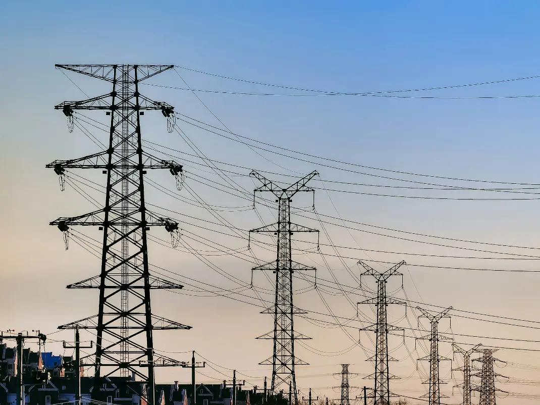 black electric post under blue sky during daytime